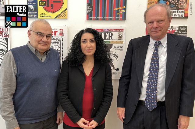 (Dieser ALT-Text wurde mithilfe von KI erstellt) Drei Personen stehen vor einer Wand mit Zeitschriften-Covern; oben links ist das Logo von Falter Radio zu sehen.