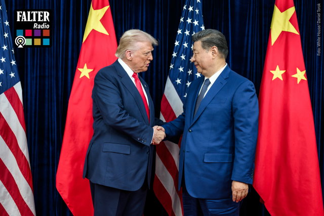 (Dieser ALT-Text wurde mithilfe von KI erstellt) Zwei Männer im Anzug geben sich vor US-amerikanischen und chinesischen Flaggen die Hand; links oben Falter Radio Logo.