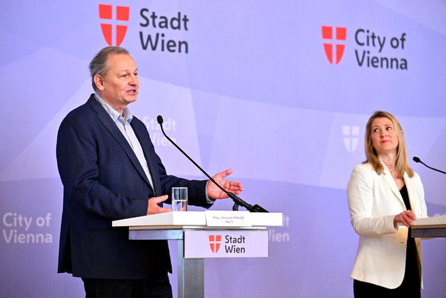 (Dieser ALT-Text wurde mithilfe von KI erstellt) Zwei Personen sprechen bei einer Pressekonferenz der Stadt Wien an Rednerpulten mit Mikrofonen vor Stadt Wien-Logos.
