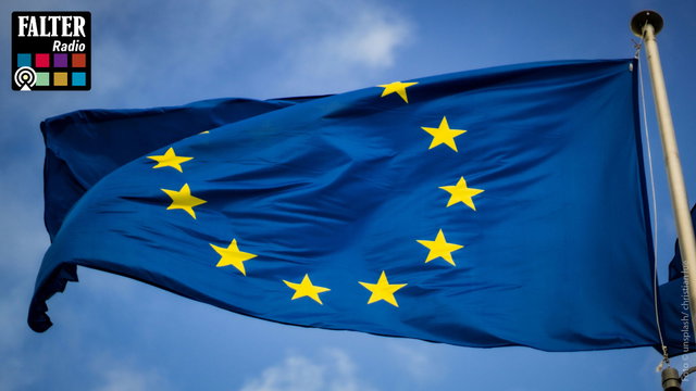 (Dieser ALT-Text wurde mithilfe von KI erstellt) Europaflagge mit gelben Sternen auf blauem Hintergrund weht an Fahnenmast, oben links Logo „Falter Radio“.